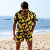 Homme sur la plage portant un Short Chemise Banane | Couleur Florale
